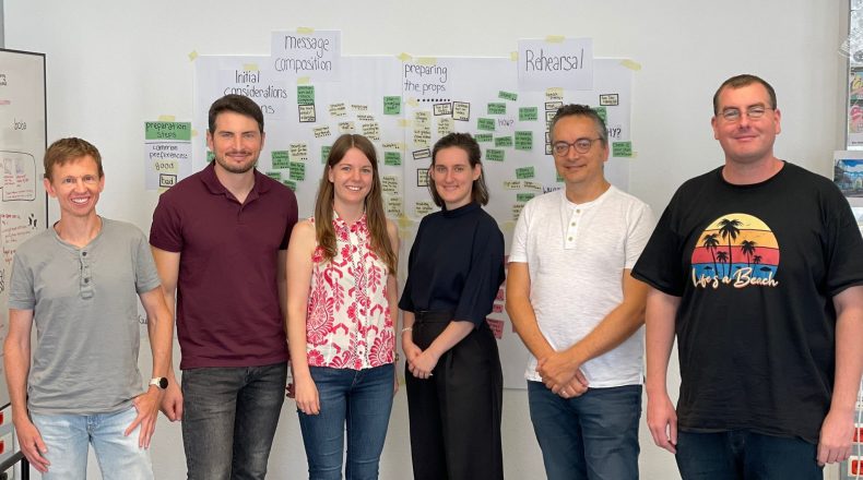 DIPF team members (six persons) standing in front of a wall. The wall is partially covered with post-its.