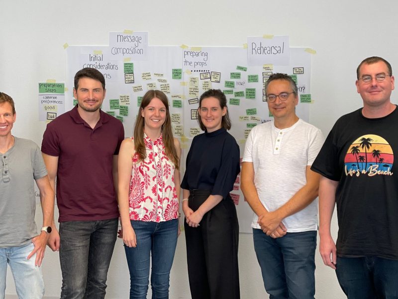 DIPF team members (six persons) standing in front of a wall. The wall is partially covered with post-its.